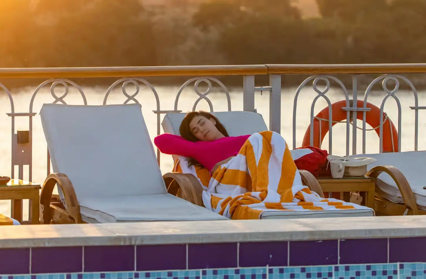A beautiful picture of a woman on a chaise lounge on a cruise ship