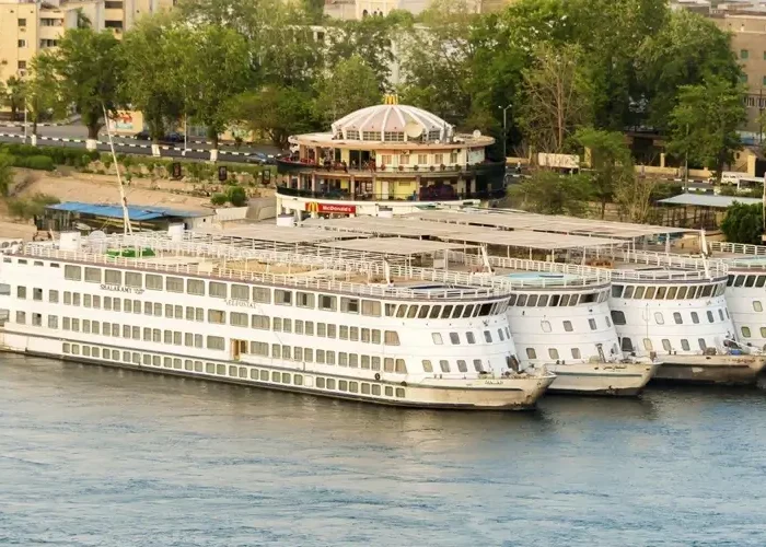 Cruise ship sailing on calm waters during sunset.