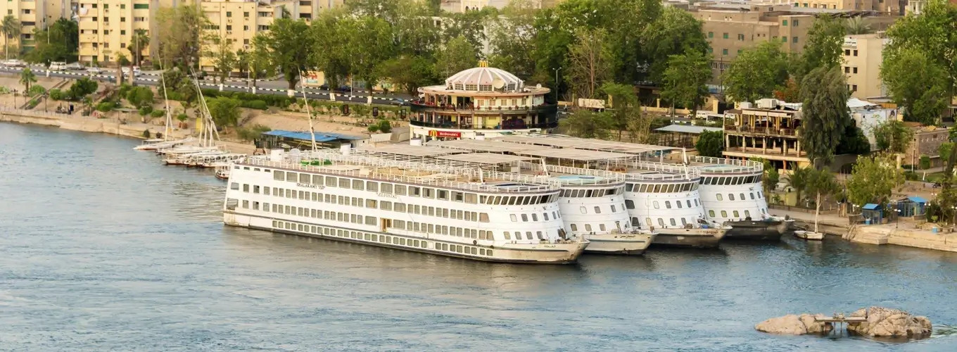 Cruise ship sailing on calm waters during sunset.