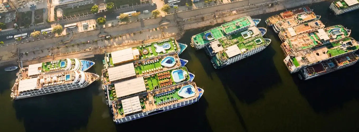 A group of Nile cruise ships lined up on the river.