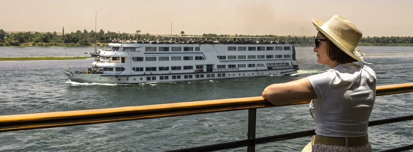Tourist on cruise ship roof with another ship passing by.