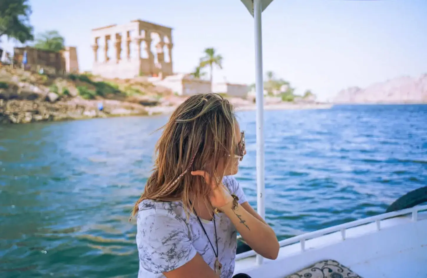 Which to choose Luxor to Aswan or Aswan to Luxor Nile Cruise? 2 A stunning photo of a tourist sitting inside a felucca on the Nile
