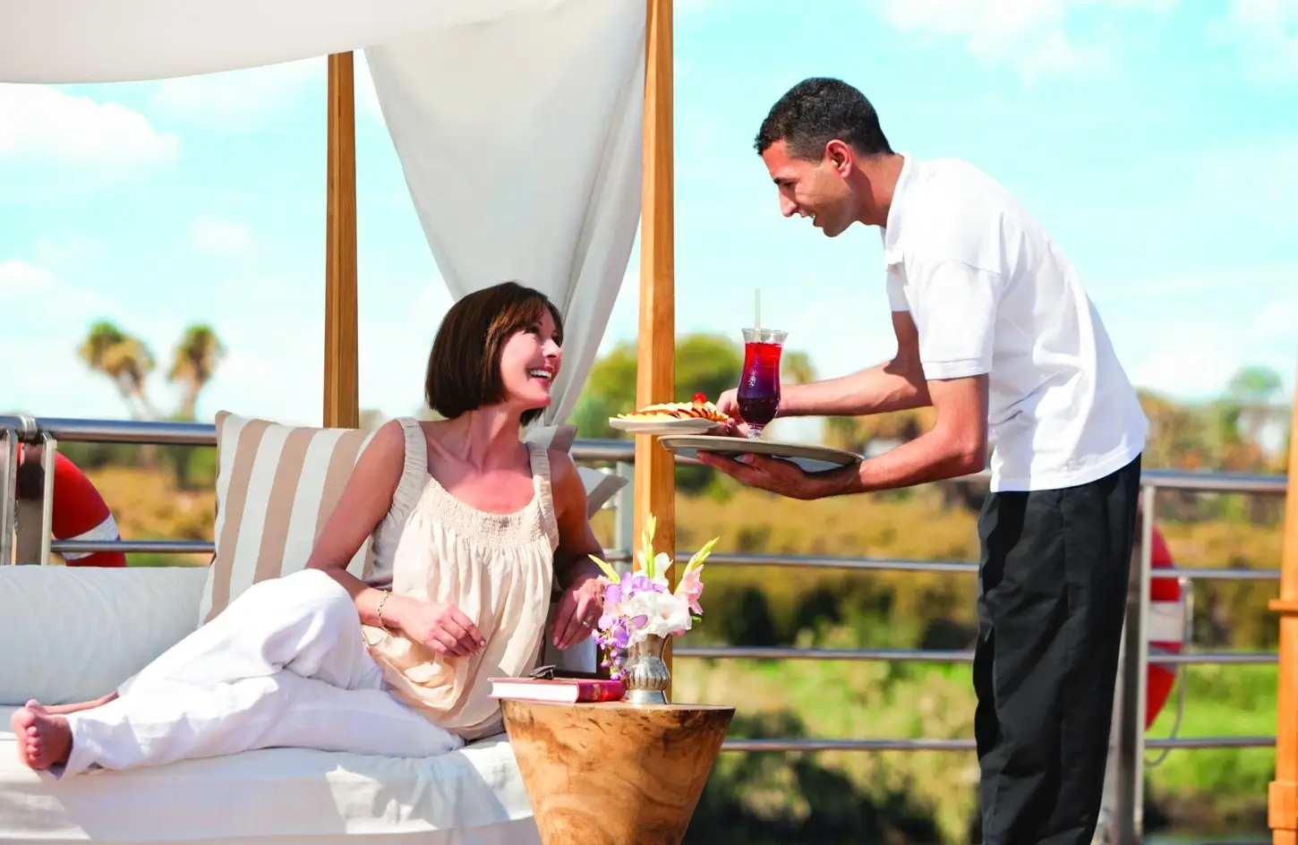A stunning photo of a tourist sitting on a bench on the deck of the cruise ship