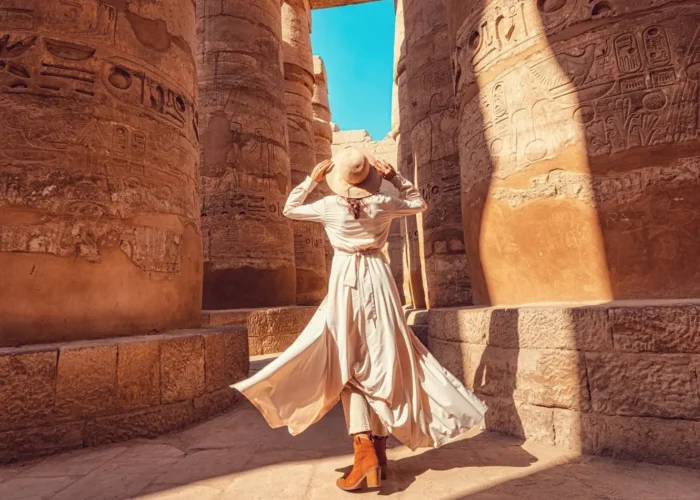 Woman observing the majestic Karnak columns from behind.