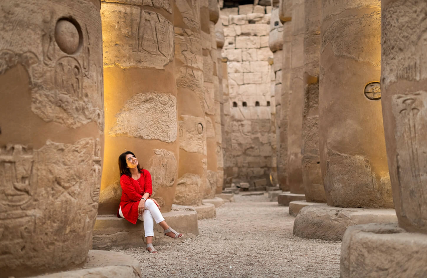A wonderful photo of a tourist sitting inside the hypostyle hall at Karnak Temple