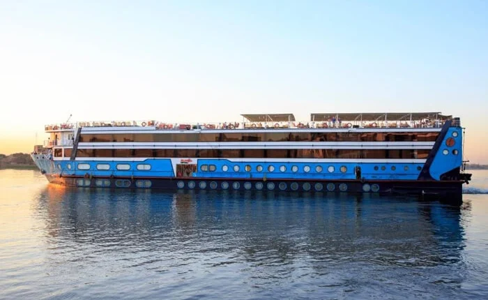 Luxurious cruise boat sailing on the Nile River at sunset.