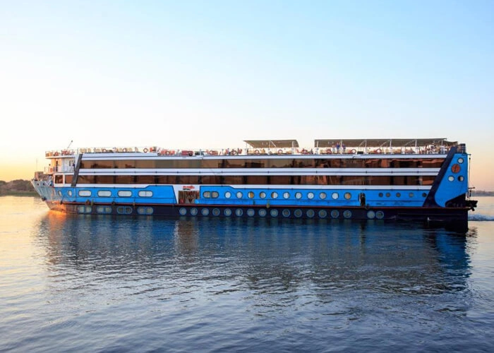 Luxurious cruise boat sailing on the Nile River at sunset.