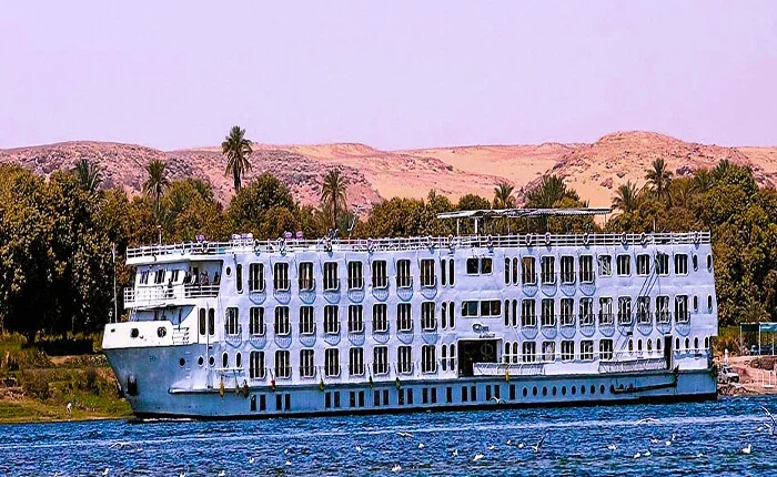 Luxury cruise boat on the Nile River during sunset.