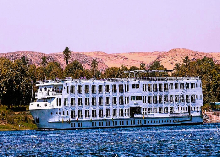 Luxury cruise boat on the Nile River during sunset.